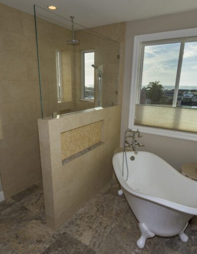 Modern bathroom with a freestanding bathtub and a walk-in shower, featuring a large window with an outside view.